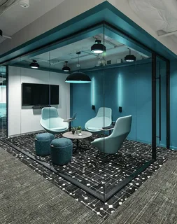 Contemporary corporate workspace with green accents and sleek workstations, demonstrating what a commercial interior designer creates for employee productivity.